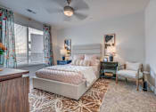 Thumbnail 22 of 45 - A bedroom with a large bed and a ceiling fan.