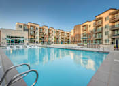 Thumbnail 31 of 45 - A large swimming pool in front of apartment buildings.