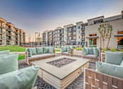 Thumbnail 35 of 45 - A modern outdoor seating area with a fire pit in the center.