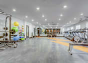Thumbnail 36 of 45 - A gym with a variety of equipment including treadmills, weights, and exercise machines.
