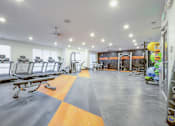 Thumbnail 37 of 45 - A gym with a variety of equipment including treadmills, weights, and exercise machines.