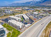 Thumbnail 45 of 45 - A large building complex is situated in the middle of a highway and a parking lot.
