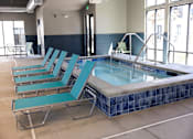 Thumbnail 13 of 34 - A pool with blue chairs around it.