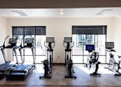 Thumbnail 16 of 34 - A gym with treadmills, exercise bikes, and elliptical machines.