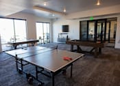 Thumbnail 26 of 34 - A ping pong table is in the middle of a room with a pool table.