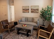 Thumbnail 2 of 34 - A living room with a grey couch, two chairs and a coffee table.