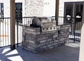Thumbnail 30 of 34 - A silver grill is on top of a stone pillar.