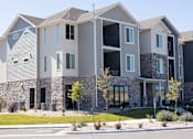 Thumbnail 32 of 34 - A modern apartment building with stone and siding exteriors.