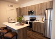 Thumbnail 4 of 34 - A modern kitchen with a white countertop and stainless steel appliances.