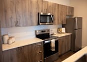 Thumbnail 5 of 34 - A kitchen with wooden cabinets and stainless steel appliances.