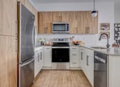 Thumbnail 2 of 6 - The Foundry Kitchen with Silver Appliances at The Foundry Apartments & Townhomes, Billings, Utah