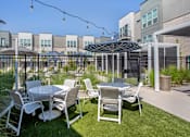 Thumbnail 33 of 39 - Tables by Pool at The Austin Townhomes