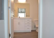 Thumbnail 7 of 16 - Modern Bathroom with White Cabinets at Kimpton Square Senior Apartments