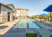 Thumbnail 29 of 38 - Swimming Pool Area With Shaded Chairs at Parc on Center Apartments & Townhomes, Orem, 84057