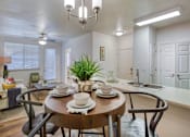 Thumbnail 6 of 32 - A dining room with a wooden table set for two.