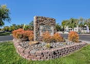 Thumbnail 1 of 46 - A stone pillar with a sign on it stands in a garden.