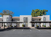 Thumbnail 38 of 46 - A building with a parking lot in front of it.