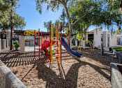 Thumbnail 45 of 46 - A playground with a red slide and yellow and blue play structures.