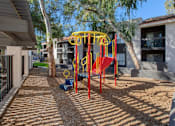 Thumbnail 41 of 46 - A playground with a red and yellow swing set.