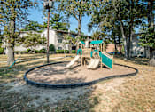 Thumbnail 13 of 14 - A playground with a green slide and a sandbox at Resident Parking at The District at Forestville Apartments, Forestville, MD, 20747