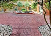 Thumbnail 18 of 18 - A red brick walkway leads to a house. Aviary Village Apartments, in Conway, SC 29526