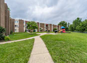 Thumbnail 13 of 14 - A playground with a blue roof is surrounded by apartment buildings.