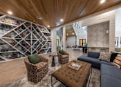 Thumbnail 4 of 30 - A community lounge in The Shiloh's clubhouse with comfortable seating near a wall with modern geometrical shelving.