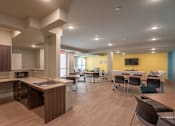 Thumbnail 14 of 17 - A modern kitchen with a dining area and a TV.
