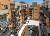 Thumbnail 1 of 17 - Apartment complex with a playground in the courtyard.