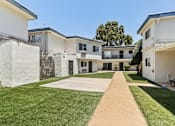 Thumbnail 8 of 10 - A white building with a long concrete pathway leading to the entrance.
