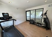 Thumbnail 12 of 44 - a workout room with mirrors on the wall and a wood floor