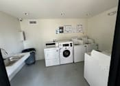 Thumbnail 10 of 44 - a laundry room with washers and dryers and a sink