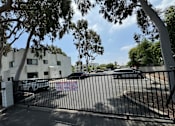 Thumbnail 4 of 44 - a gate with cars parked in front of a building