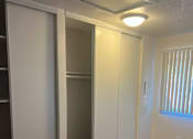 Thumbnail 6 of 7 - a carpeted room with three closets and a window