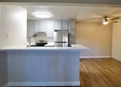 Thumbnail 4 of 30 - an empty kitchen with a island and a ceiling fan