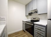 Thumbnail 5 of 30 - an empty kitchen with black appliances and white counter tops