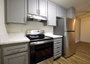 Thumbnail 6 of 30 - a kitchen with black appliances and white counter tops at Brookhollow Apartments, West Covina , California
