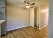 Thumbnail 9 of 30 - an empty living room with a ceiling fan and a closet