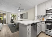 Thumbnail 14 of 38 - an open kitchen and living room with a large counter top at Harbor Terrace Apartments, San Pedro , CA