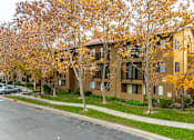 Thumbnail 4 of 13 - Apartment building with trees in autumn colors.
