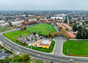 Thumbnail 5 of 13 - A road with a grassy area and a building in the distance.