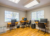 Thumbnail 8 of 13 - A room with a desk, chairs, and computers.