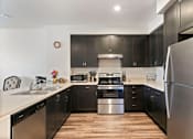 Thumbnail 15 of 21 - a kitchen with stainless steel appliances and black cabinets
