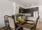 Thumbnail 5 of 21 - a kitchen and dining room with a table and chairs