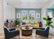 Thumbnail 8 of 21 - a living room with blue walls and a couch and chairs