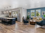 Thumbnail 4 of 21 - a living room with a kitchen and a table and chairs