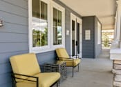 Thumbnail 7 of 21 - the front porch of a house with two chairs and a table