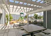 Thumbnail 17 of 21 - an outdoor patio with picnic tables and a playground