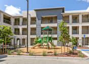 Thumbnail 19 of 21 - an apartment building with a playground in front of it