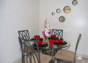 Thumbnail 7 of 12 - a dining area with a round glass table and chairs